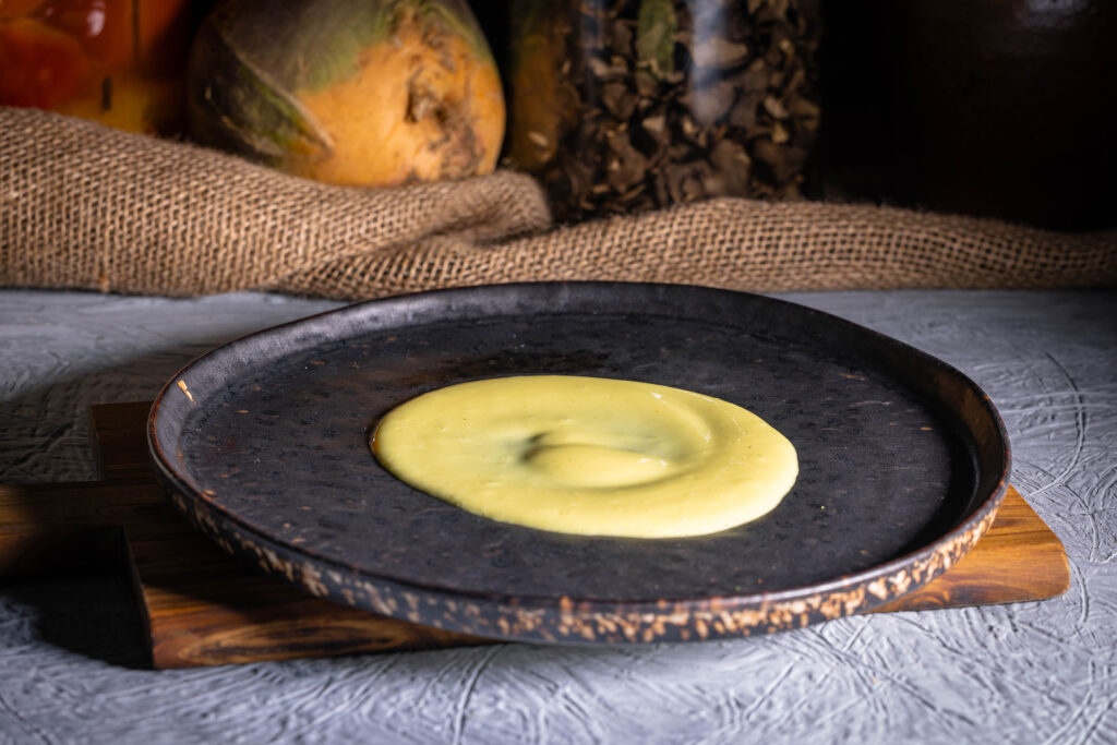 Vegane Sauce Béarnaise auf einem Teller angerichtet.