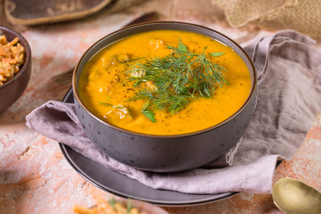 Süßkartoffel-Kokos-Suppe in einer Schüssel mit Dill garniert.