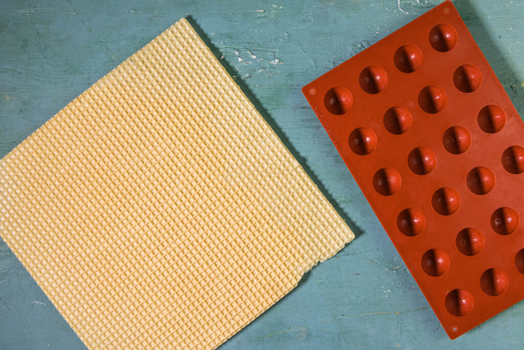 Ein Waffelboden und eine Silikonform mit halben Sphären.