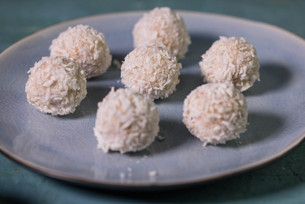 Vegane Raffaello auf einem blauen Teller.