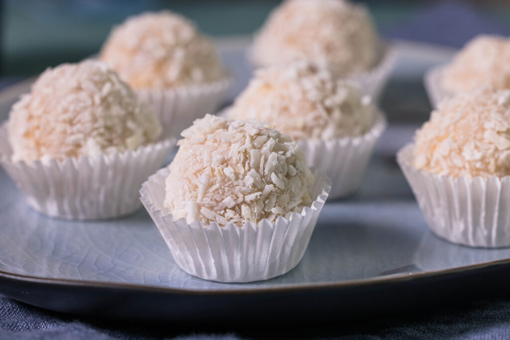 Ein blauer Teller auf dem vegane Raffaellos, Vaffaellos, liegen.