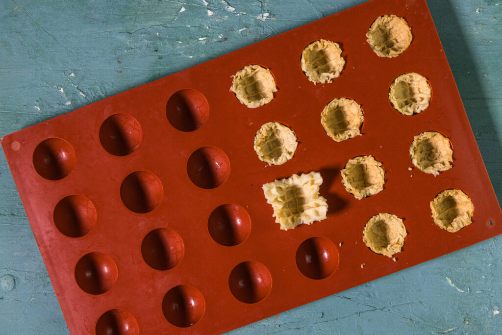 Eine Silikonform, teilweise sind die Sphären mit Waffelblättern gefüllt.