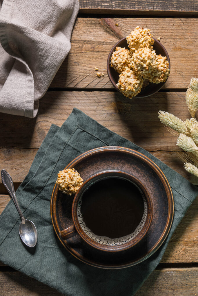 Viotto - vegane Giotto selbst gemacht - in einer Schale. Daneben eine Tasse Kaffe, auf der Untertasse auch ein Giotto. Und ein halbiertes, bei dem man Waffel und Creme sieht davor.