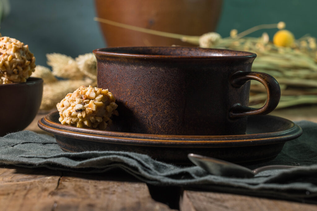 Eine Tasse Kaffe, auf der Untertasse ein veganes Giotto.