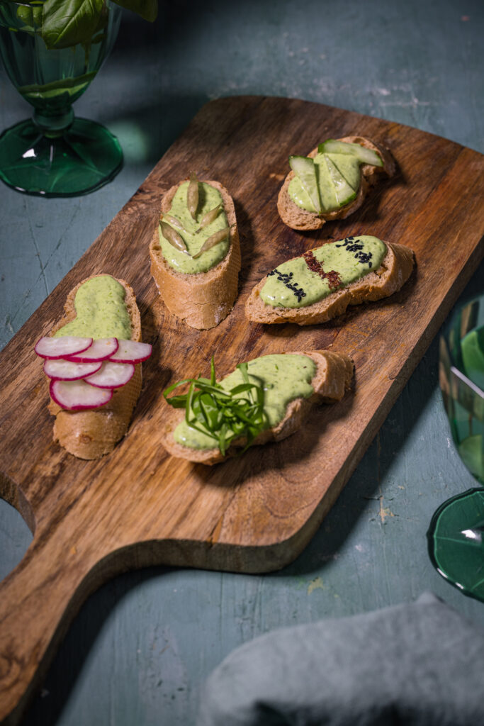 Bälrauch Aioli auf Baguetteschieben mit verschiedenen Toppings.