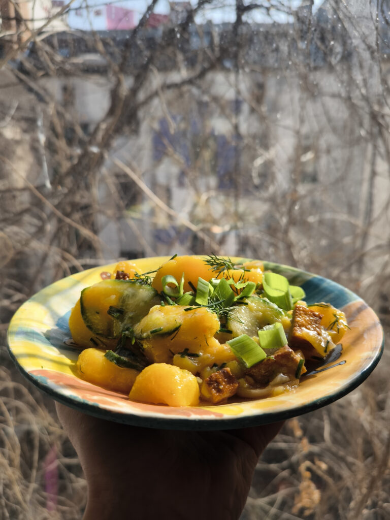 Bayrischer Kartoffelsalat - herzhaft, deftig, mit frischer Gurke und veganem, frisch gebratenem Speck.