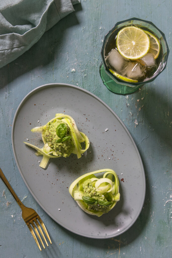 Die rohen Zucchini-Tagliatelle schmecken herrlich frisch mit dem würzig-knoblauchigem Avocado-Pesto.