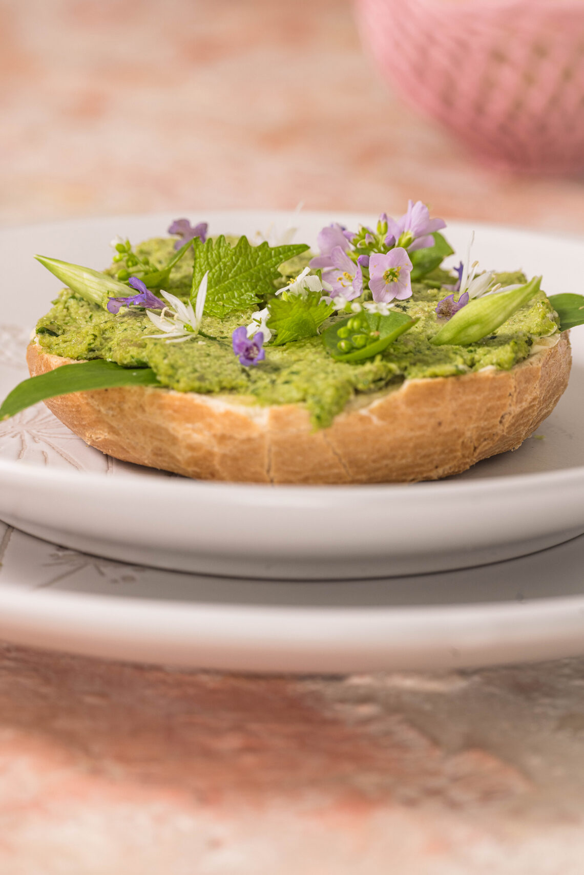 Bärlauchstreich - Brotaufstrich - auf einem Bagel mit essbaren Blüten garniert