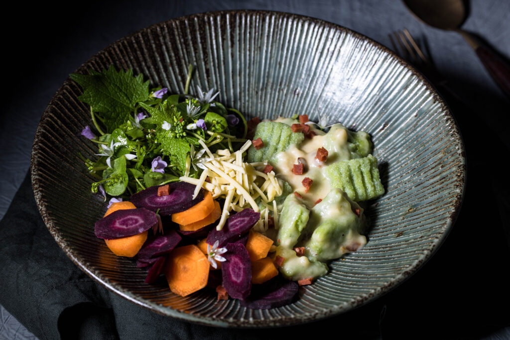 Bärlauch Gnocchi – vegan – mit pflanzlicher Käse-Schinken-Soße in einer Bowl mit Wildkräutersalat und Möhren.