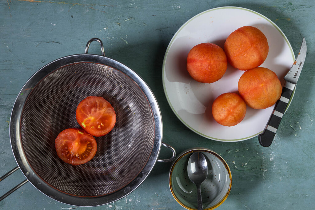 Die Tomaten über einem Sieb entkernen, den Saft dabei auffangen.