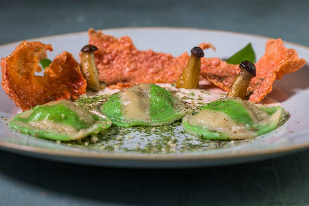 Gestreifte Bärlauch-Ravioli auf hellem Tomatenschaum
