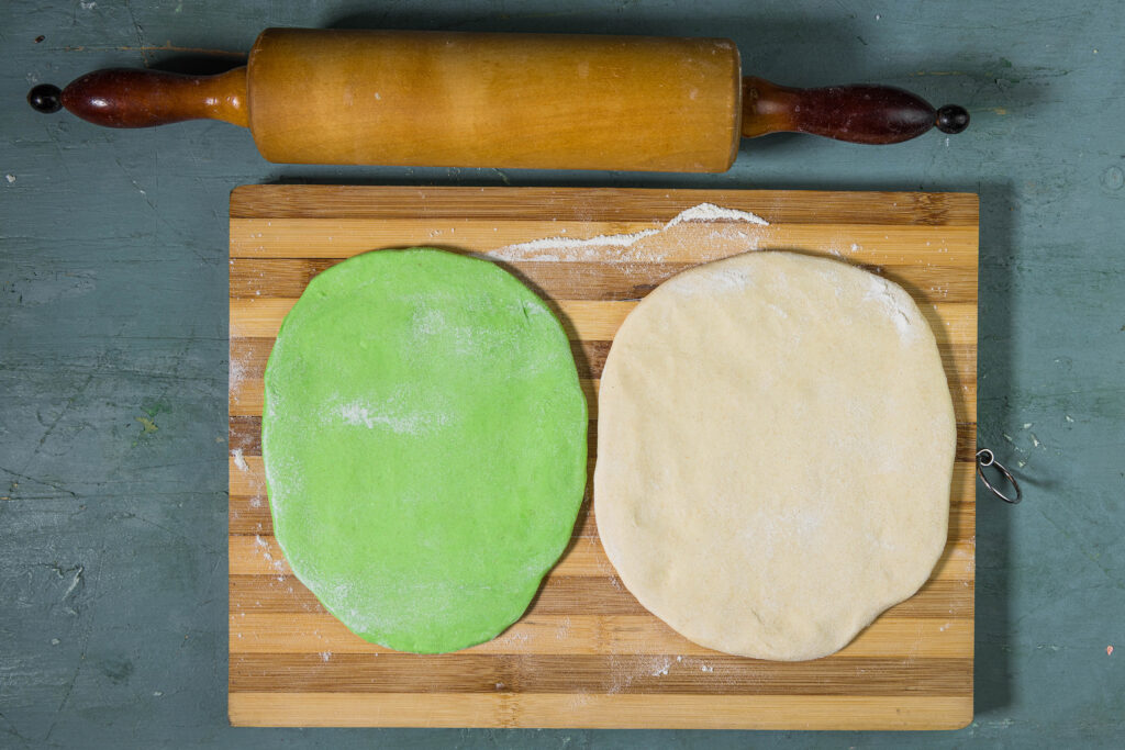 Zwei Ravioliteige, etwa einen halben Zentimeter dick. Der eine ist grün, der andere weiß.