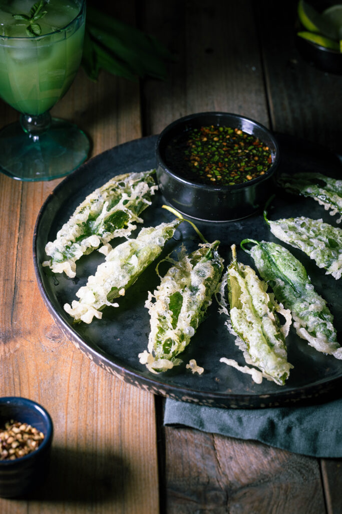 Bärlauch-Tempura mit Bärlauch-Dip auf einem dunklen Teller.