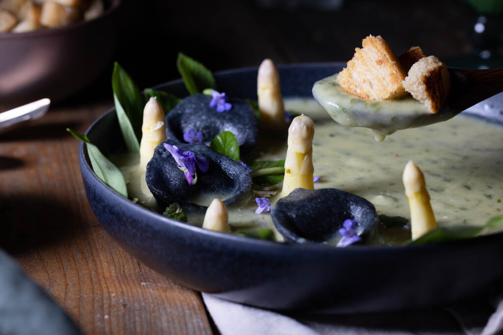 Bärlauch-Kartoffel-Cremesuppe: vegane Bärlauchsuppe, Auf einem Löffen sieht man frische Croutons mit Suppe.