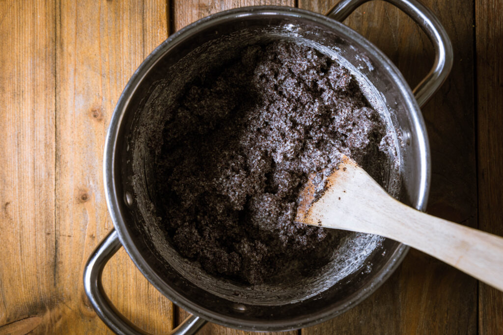 Vegane Mohnfüllung wird in einem Kochtopf zubereitet.