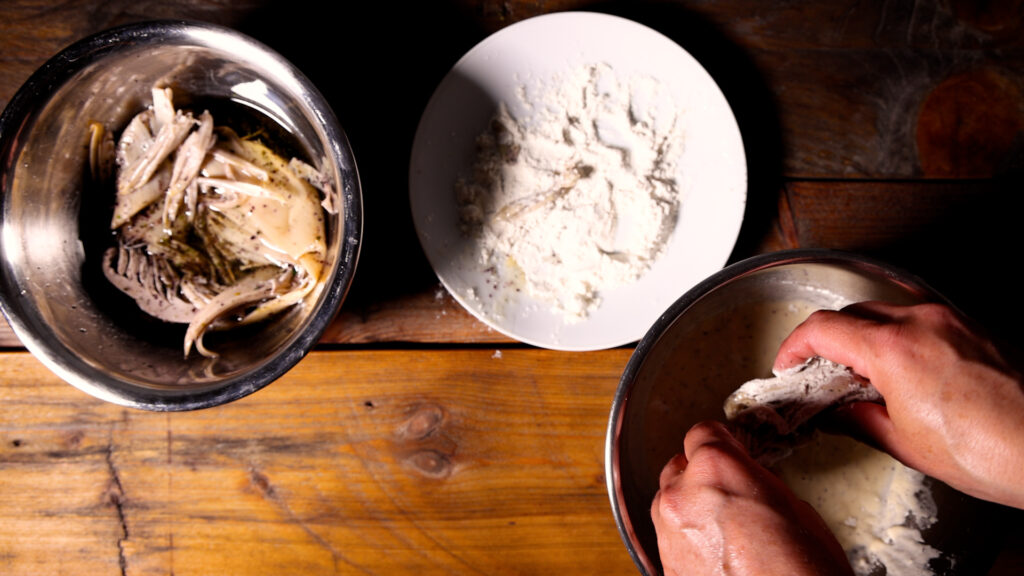 Veganer Backfisch aus Bananenblüten wird paniert.