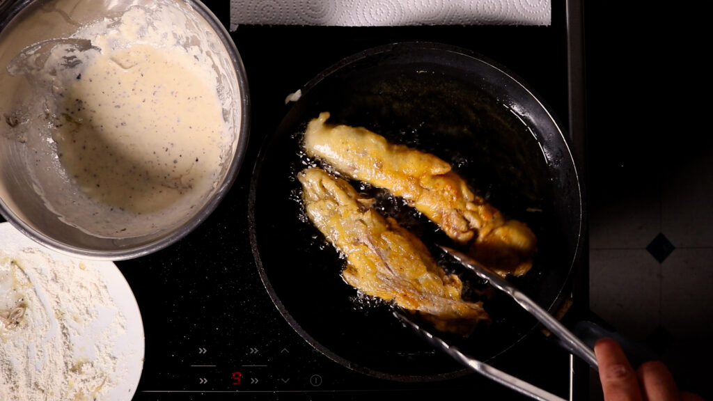 Veganer Backfisch wird in reichlich Öl in einer Pfanne ausgebacken.