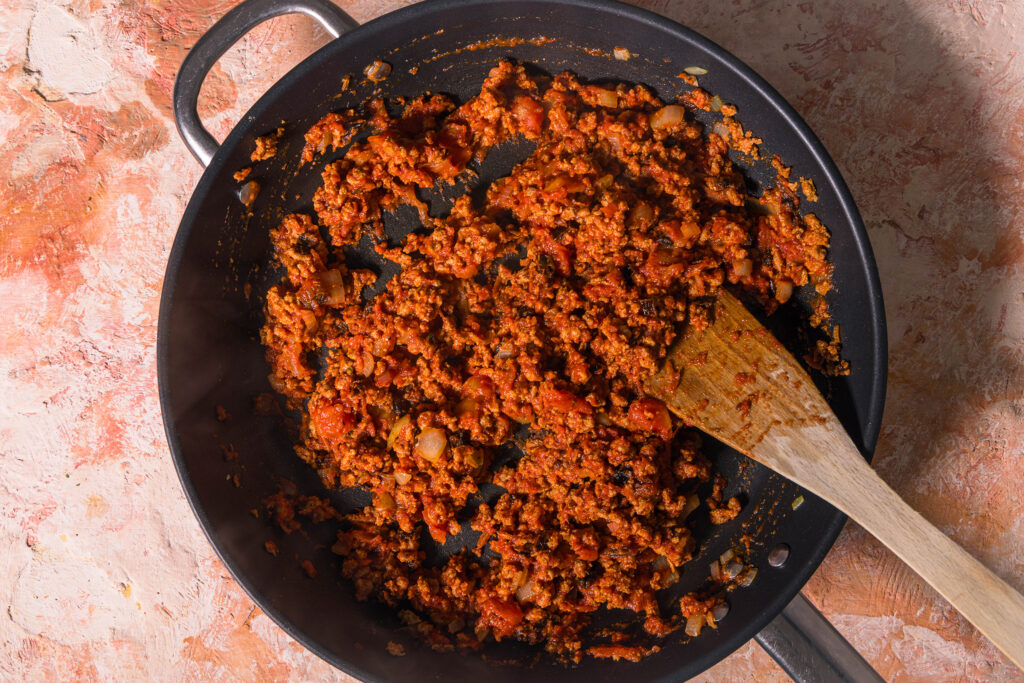 Vegane Hackfüllung für eine Lasagne wird in einer Pfanne vorbereitet.