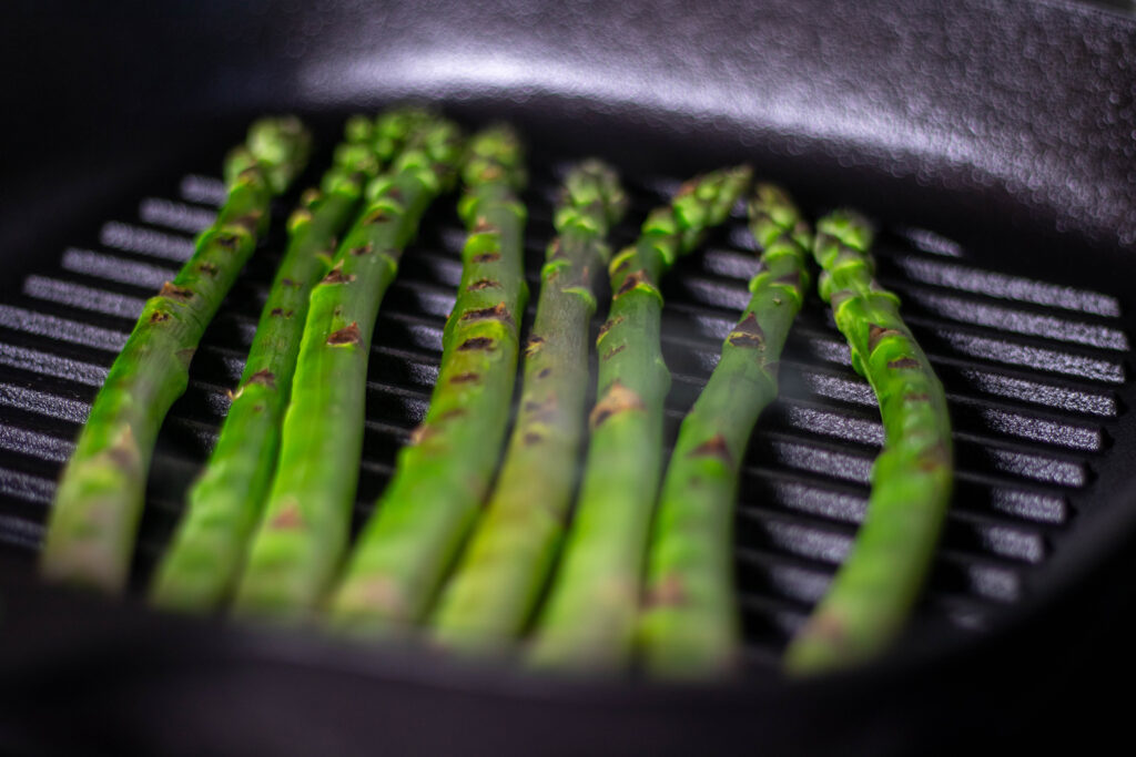 Grüner Spargel in einer Grillpfanne.