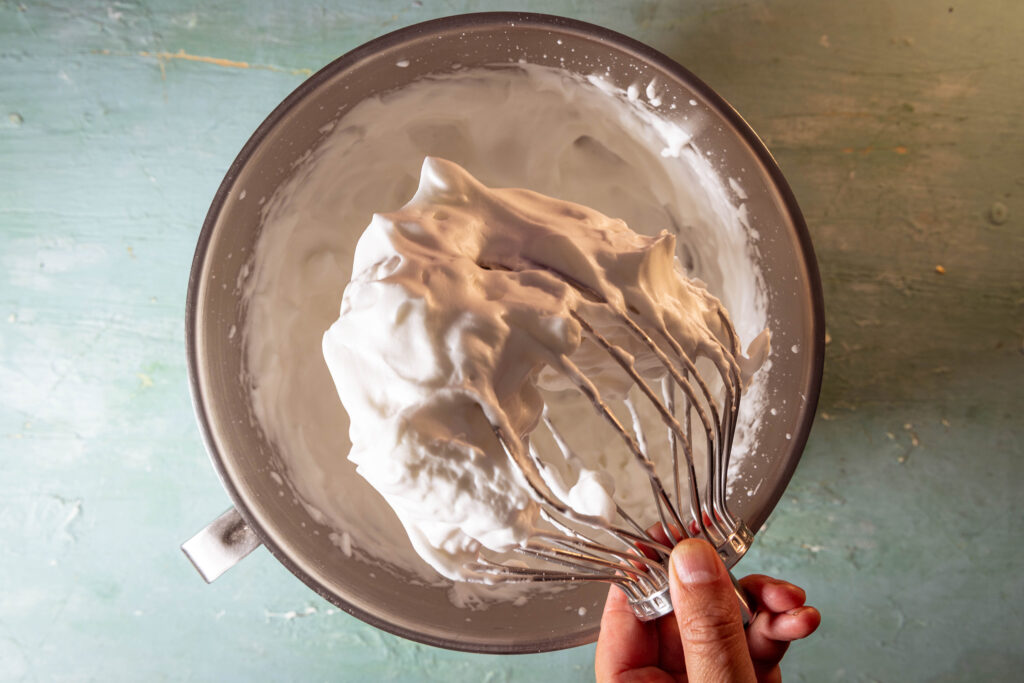 Aufgeschlagenes Aquafaba in einer Schüssel und an einem Schneebesen.