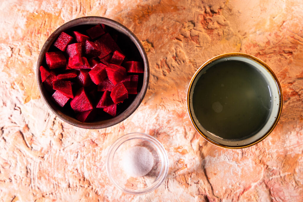 Rote Beete Würfel in einer Schale, Zitronensaft und Salz in weiteren Schalen.