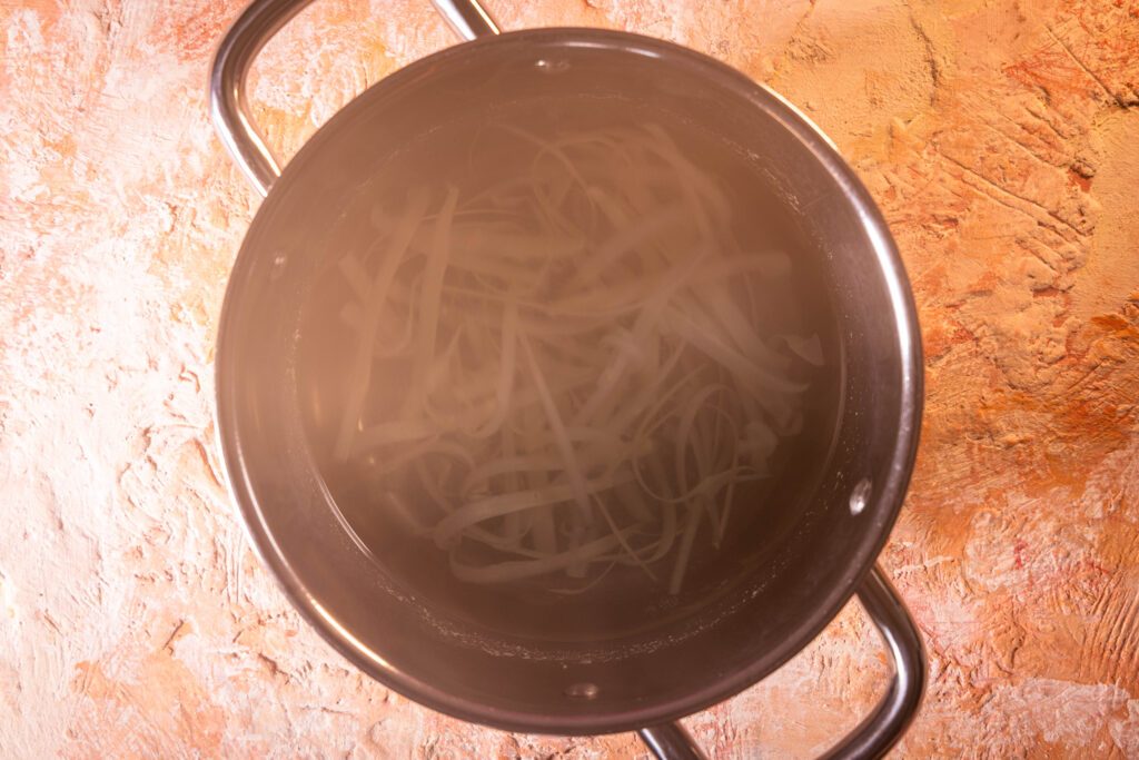 Spargelschalen kochen im Wasser in einem Topf.