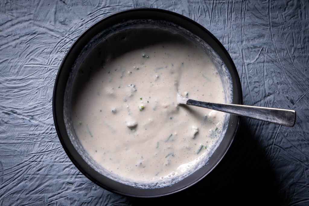 Eine Schale mit rein pflanzlichem Blauschimmeldip. Mit einem Löffel darin.
