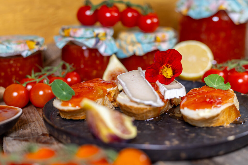 Tomatenkonfitüre auf Brot und in Gläsern.