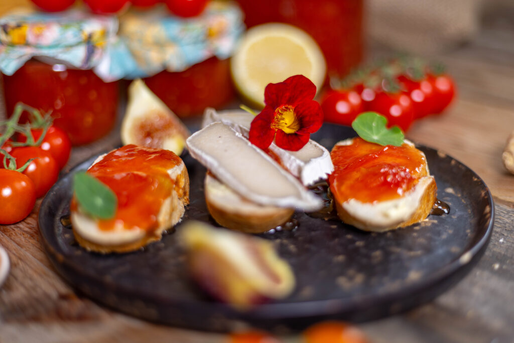 Tomatenkonfitüre auf Brotscheiben. Teilweise mit veganem Camembert.