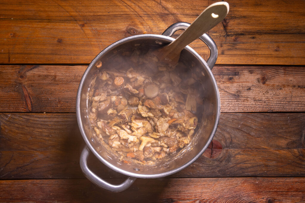 Eine Suppe aus Waldpilzen wird in einem Topf zubereitet.