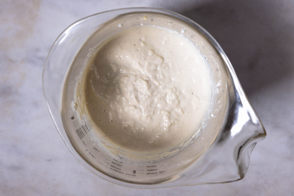 Frisch zubereiteter, veganer Ricotta in einem Messbecher.