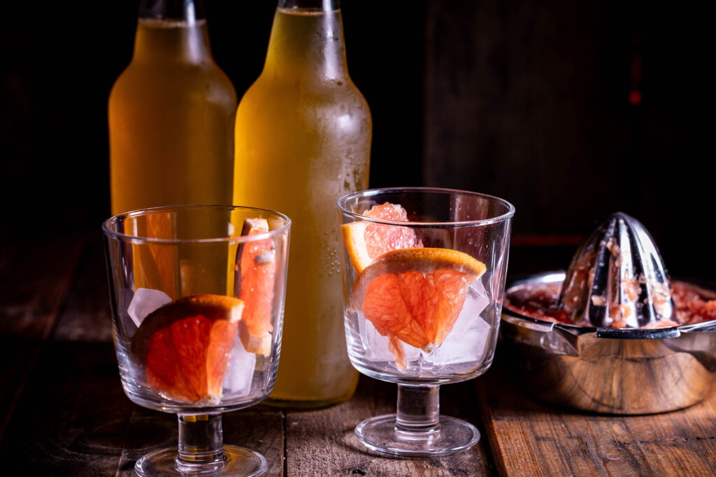 Eiswürfel und Grapefruitstücke in Gläsern.