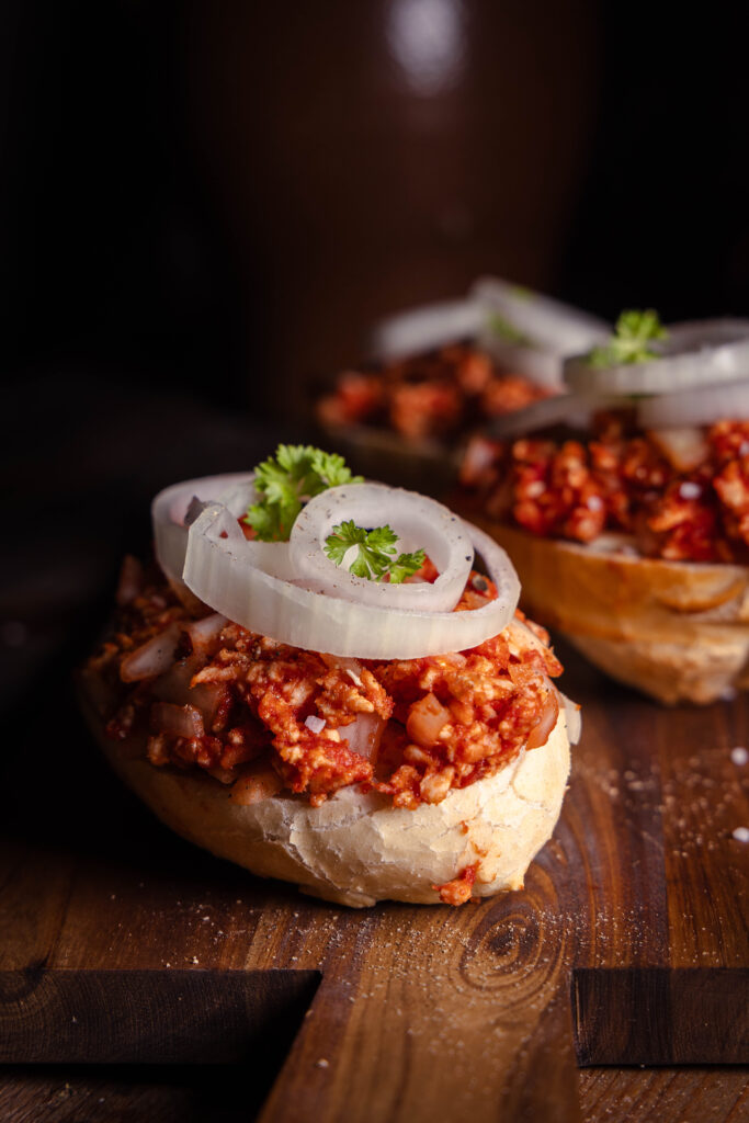 Veganes Mett mit Zwiebelringen auf Brötchen