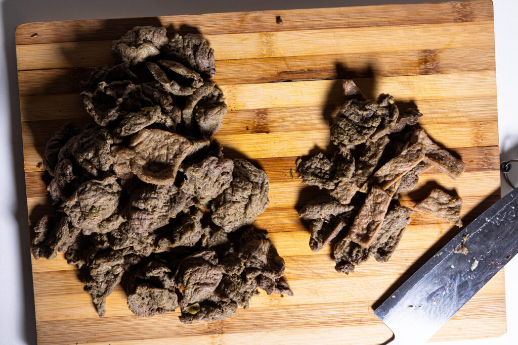 Veganes Rindfleisch aus Soja wird in dünne Streifen geschnitten.