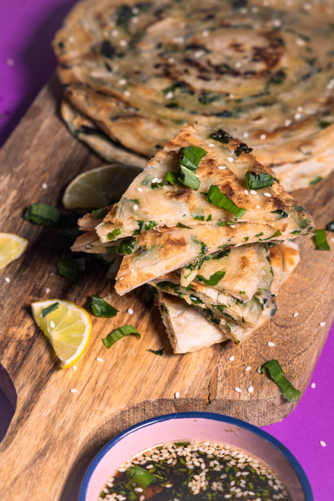 Chinese Scallion Pancakes, hier alternativ mit Bärlauch und Dip, auf einem Holzbrett