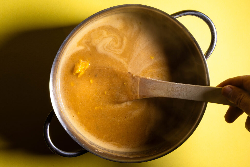 Eine vegane Sopa de Ajo mit gestocktem Ei in einem Kochtopf.