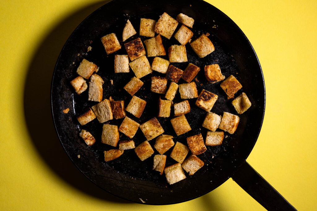 Croutons braten in einer Pfanne.