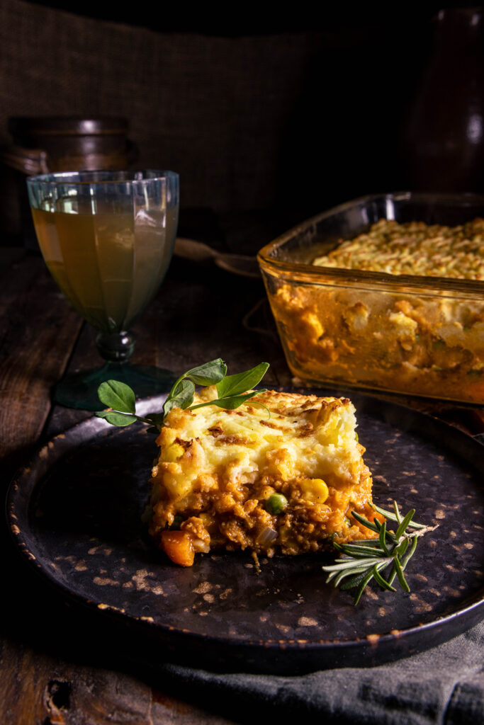 Veganer Sheperd's Pie auf einem Teller und in einer Auflaufform