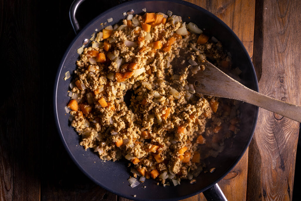 Eine vegane Fleischfüllung wird in einer Pfanne zubereitet.