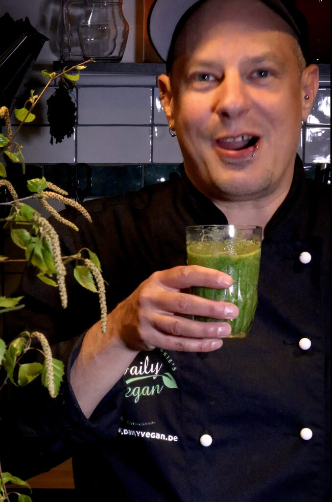 Sean Moxie mit einem grünen Wildkräuter-Birkenblatt-Smoothie in der Hand
