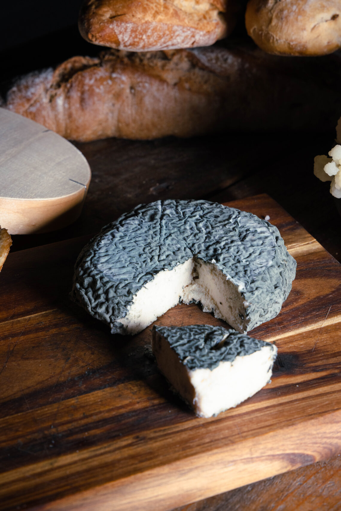 Blumenblau – Veganer Blauschimmelkäse auf Blumenkohlbasis - angeschnitten auf einem Holzbrett