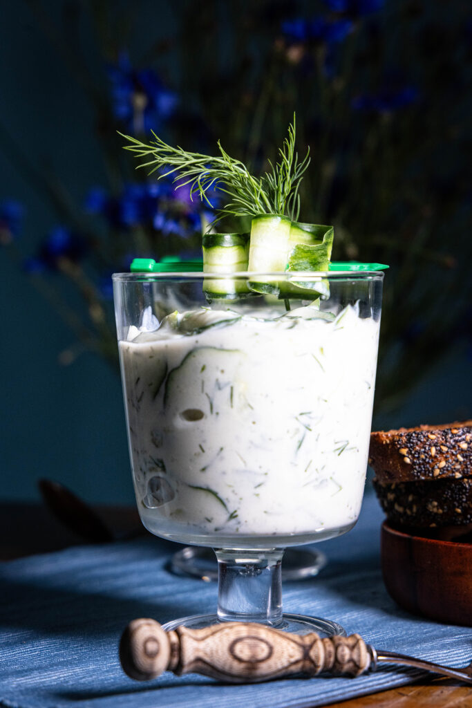 Gurkensuppe in einem Glas, mit gehobelter Gukre und Dill dekoriert.